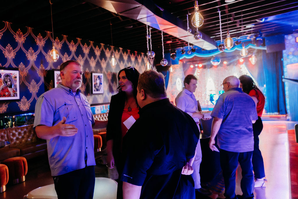 Guests talking under warm bulb lighting at a Connect or Die activation